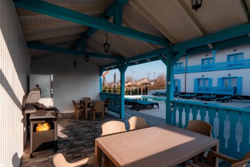 a patio with a table and a fireplace next to a pool at Vila Mavis-cazare cu piscina incalzita 1 mai-30 sept in Mahmudia