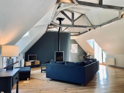 a living room with a blue couch in a loft at Le Petit Bourdieu - Sanglier in Jurançon