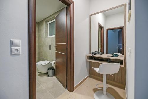 y baño con aseo, lavabo y espejo. en A & G Apartments en Kolymvari