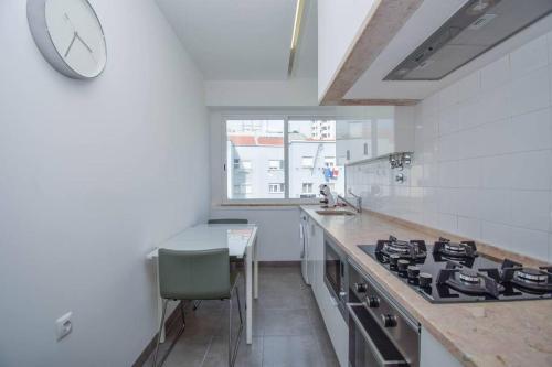 a kitchen with a stove and a clock on the wall at Cozy and Sunny Family Apartment in Lisbon