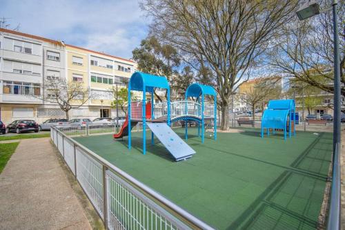 a playground with a slide in a park at Cozy and Sunny Family Apartment in Lisbon