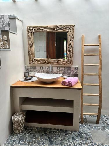 a bathroom with a sink and a mirror at Villa Anjing in Nusa Dua