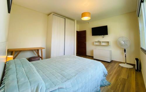 1 dormitorio con 1 cama y TV de pantalla plana en Ubatuba en Balneario Mar Azul