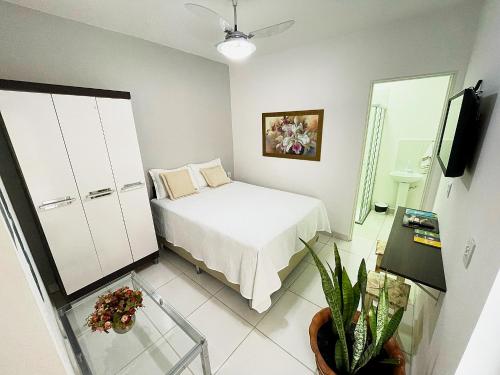 a small bedroom with a bed and a plant at Temporada Cuiabana in Cuiabá