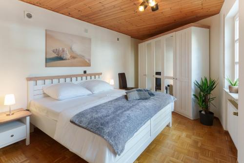 um quarto com uma grande cama branca e um tecto de madeira em Casa Benedicta em Trier