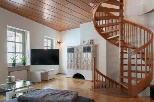 a living room with a spiral staircase and a television at Casa Benedicta in Trier