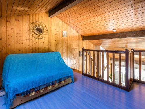 - une chambre avec un lit bleu dans un mur en bois dans l'établissement Duplex 2 chambres au centre village, proche pistes, avec garage et balcon - FR-1-437-28, à La Clusaz
