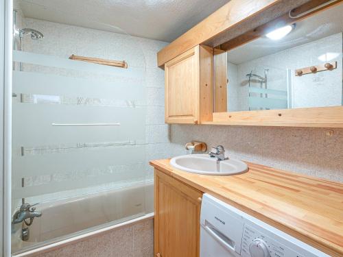 une salle de bain avec un lavabo et un miroir et une machine à laver dans l'établissement Charmant 3 pièces centre La Clusaz, 300m des pistes, balcon Sud, 6 pers, parking et ski à proximité - FR-1-437-84, à La Clusaz