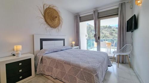 een slaapkamer met een bed, een televisie en een balkon bij Private balcony, sunny all year round, with nice views in Benidorm