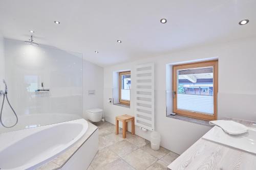 a white bathroom with a tub and a window at Chalet Chiemgau in Reit im Winkl