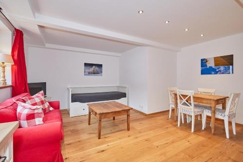 a living room with a red couch and a table at Chalet Chiemgau in Reit im Winkl