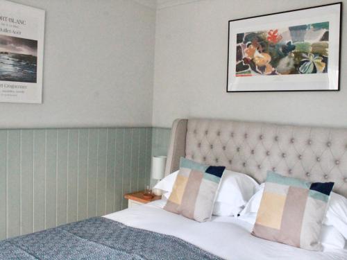 a bedroom with a bed and a picture on the wall at The Bosham Boathouse in Chichester