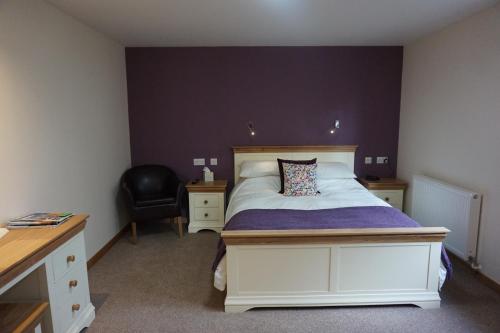 a bedroom with a bed and a desk and a chair at Karrawa Guest House in Kirkwall