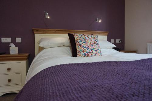 a large bed with a pillow on top of it at Karrawa Guest House in Kirkwall