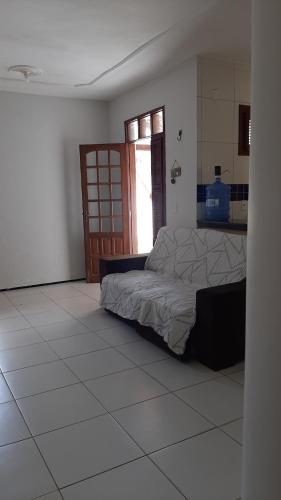 een slaapkamer met een bed en een tegelvloer bij Cantinho arretado da Peste - Casa in Aquiraz