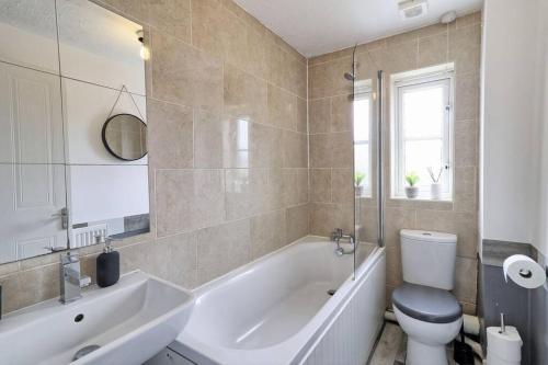 y baño con bañera, aseo y lavamanos. en Luxury 2 Bedroom House with Garden & Free Parking, en West Thurrock