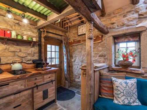 a kitchen in a log cabin with a stove at Woolcombers in Addingham