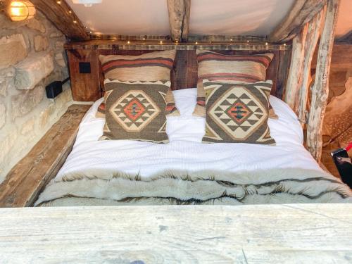 a bed in a tiny house with pillows at Woolcombers in Addingham