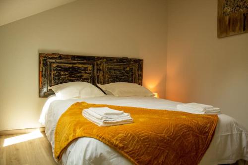 Schlafzimmer mit einem Bett mit weißer Bettwäsche und Kissen in der Unterkunft Le Triplex - 4 pers - Wifi - Centre ville in Mende