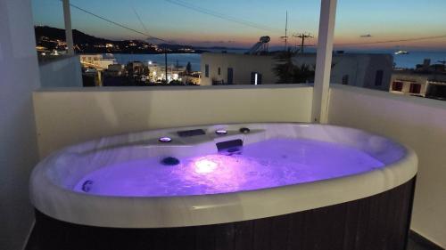 a purple bath tub in a room with a window at Fabrica Sunset Apartments in Megali Ammos
