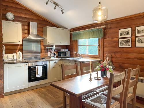cocina con paredes de madera y mesa de madera en Squirrel View en Newtonmore