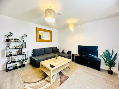 ein Wohnzimmer mit einem Sofa und einem Tisch in der Unterkunft Hemel Apartments- Sunset retreat in Hemel Hempstead