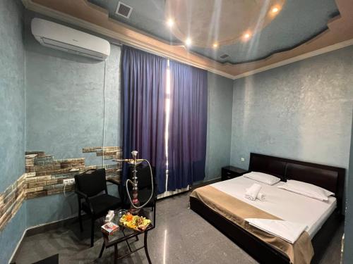 a bedroom with a bed and a table and a chair at JOY Hotel in Yerevan