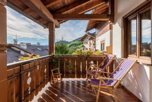 a balcony with two rocking chairs and a window at Appartements Pension Sonia in Funes