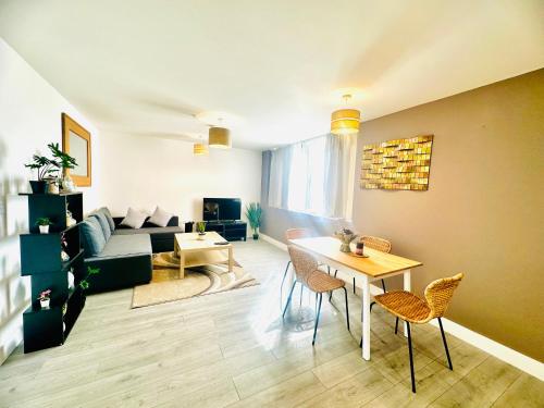 uma sala de estar com um sofá, uma mesa e cadeiras em Hemel Apartments- Sunset retreat em Hemel Hempstead