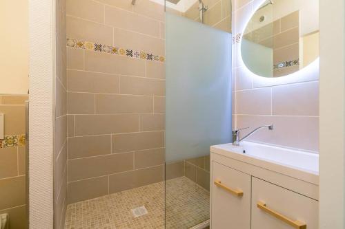 une salle de bain avec une douche, un lavabo et un miroir dans l'établissement Terrasse Godrans en plein cœur de ville, à Dijon