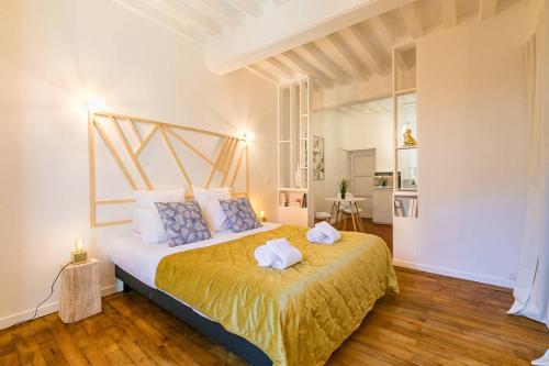 une chambre avec un grand lit avec deux serviettes dessus dans l'établissement Terrasse Godrans en plein cœur de ville, à Dijon