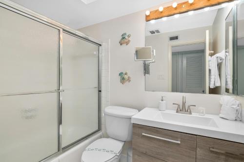 a white bathroom with a shower and a sink at Sea Gem 803 in Naples