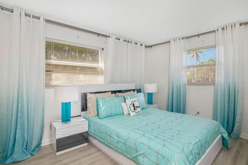 a blue bedroom with a bed and two windows at Sea Gem 803 in Naples