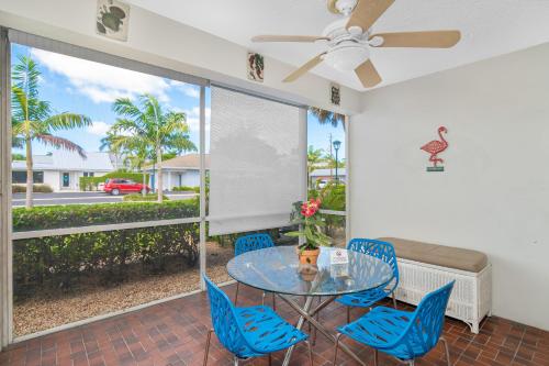 a dining room with a glass table and blue chairs at Sea Gem 803 in Naples