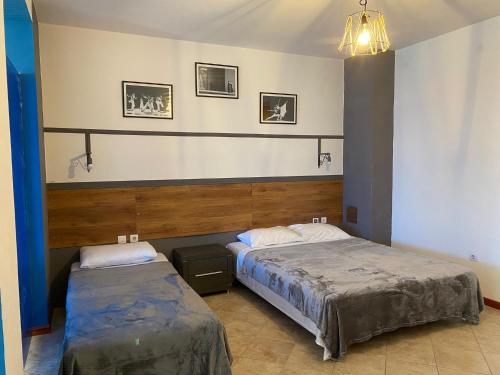 1 dormitorio con 2 camas y lámpara de araña en Budva Metaxi Suits en Budva