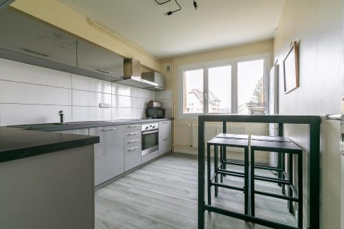 - une cuisine avec un comptoir et deux tabourets dans l'établissement LE TERROIR, au calme à deux pas du centre ville, à Dijon