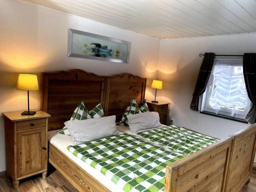 a bedroom with a large wooden bed with a checkered bedspread at FeWo Marie im Ferienhaus Selma in zentraler Lage in Großschönau