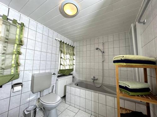 ein Badezimmer mit einem WC und einer Badewanne in der Unterkunft FeWo Marie im Ferienhaus Selma in zentraler Lage in Großschönau