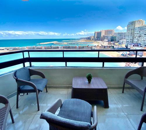 einen Balkon mit Stühlen, einem Tisch und Meerblick in der Unterkunft Alexandria Luxury Apartments Gleem 2 Direct Sea View in Alexandria