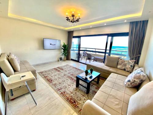 ein Wohnzimmer mit einem Sofa und einem Tisch in der Unterkunft Alexandria Luxury Apartments Gleem 2 Direct Sea View in Alexandria