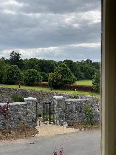 a stone wall with a gate in a garden at The Coach House at Moyglare Manor in Maynooth