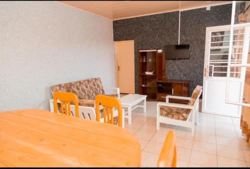 a living room with a dining room table and chairs at Auberge La Caverne in Kigali
