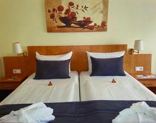 - 2 lits avec des oreillers bleus dans une chambre d'hôtel dans l'établissement Savoy Hotel, à Francfort-sur-le-Main