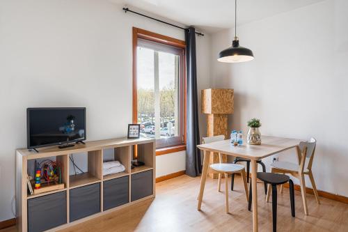 a living room with a table and a tv at Coreto Apartment in Vila do Conde