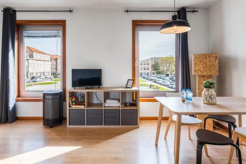 a living room with a table and a television at Coreto Apartment in Vila do Conde