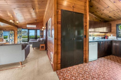 a kitchen and living room with a large sliding door at Lakefront Gem - Kuratau Holiday Home in Kuratau
