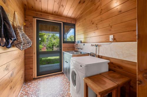 a kitchen with a washing machine and a sink at Lakefront Gem - Kuratau Holiday Home in Kuratau