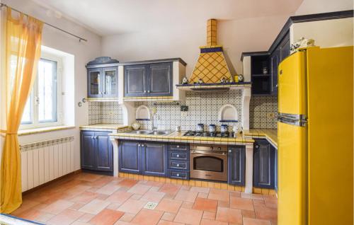 une cuisine avec des armoires bleues et un réfrigérateur jaune dans l'établissement 3 Bedroom Beautiful Apartment In Bonifati, à Bonifati