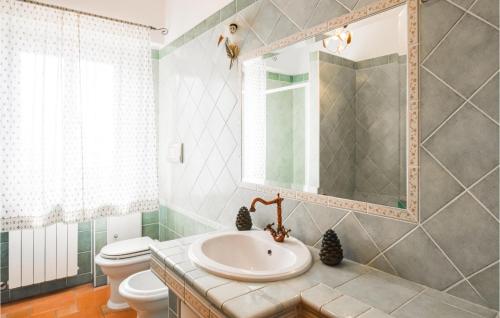 La salle de bains est pourvue d'un lavabo, de toilettes et d'un miroir. dans l'établissement 3 Bedroom Beautiful Apartment In Bonifati, à Bonifati