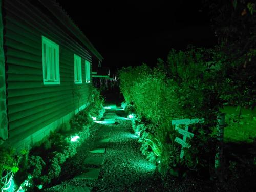 a backyard at night with green lights next to a house at Pousada Cabanas Xokleng in Urubici
